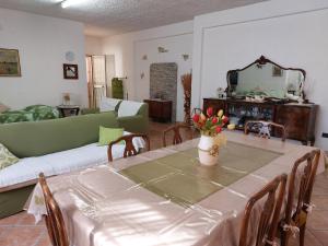 een woonkamer met een tafel en een bank bij Casa con giardino Giacalone in Mazara del Vallo