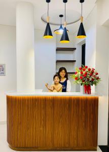 a woman standing behind a counter with a child at Anstay Beach Da Nang in Da Nang