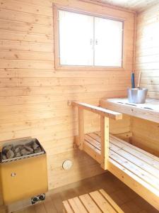 une cabine en bois avec un banc et une fenêtre dans l'établissement Rivitalon lomahuoneisto Tahkolla, à Tahkovuori