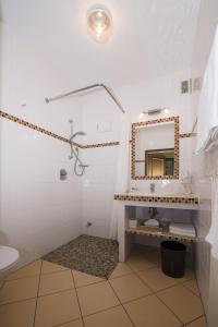 ein Bad mit einem Waschbecken und einem Spiegel in der Unterkunft Land-gut-Hotel Rohdenburg in Lilienthal