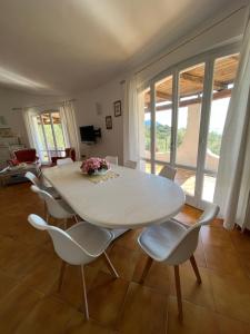 a dining room with a white table and chairs at Casa Le Cicale in Porto Istana