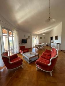 a living room with red chairs and a table at Casa Le Cicale in Porto Istana