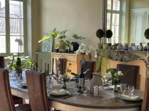 une table à manger avec des chaises et une longue table avec des verres dans l'établissement Maison M on the Dordogne, à Sainte-Foy-la-Grande