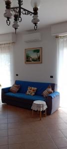 um sofá azul numa sala de estar com uma mesa em Girasole76 em Sestri Levante