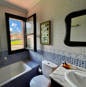 a bathroom with a toilet and a tub and a sink at Hotel Rural El Texeu in Llanes