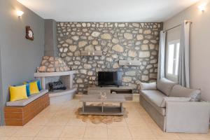 a living room with a couch and a fireplace at Serenity Villa in Karpathos
