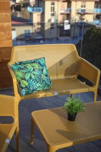 a yellow wicker bench with a pillow on a patio at Casarella in Castel di Sangro