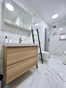 a white bathroom with a sink and a toilet at Apartments Cvitanović Korčula in Korčula