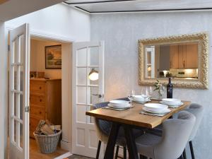 a dining room with a table and a mirror at Sandend in Lytham St Annes