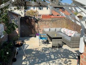 un patio con sofá, mesa y parrilla en Sandend en Lytham St Annes