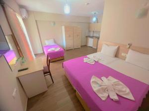 um pequeno quarto com uma cama roxa e uma cadeira em Figen Suite Hotel 2 em Çanakkale