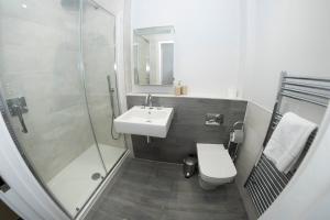 a bathroom with a sink and a shower and a toilet at 3 Putsborough - Luxury Apartment at Byron Woolacombe, only 4 minute walk to Woolacombe Beach! in Woolacombe