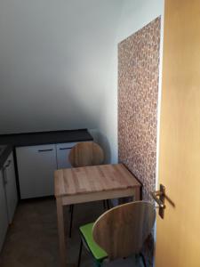 une cuisine avec une table en bois et deux chaises dans l'établissement Ferinwohnung an der Promnitz Radeburg, à Radeburg