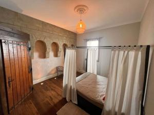 a bedroom with a bed with a curtain and a window at Cabana & Nuit de Château au bord du Lac Léman in Lugrin