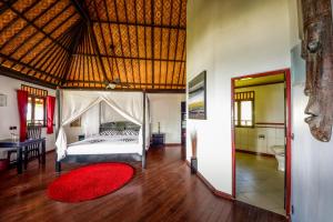 a bedroom with a bed and a red rug at Bali Villa Dive Resort in Gretek