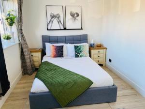 Un dormitorio con una cama con una manta verde. en The Ely Retreat en Ely