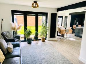 a living room with a couch and potted plants at The Ely Retreat in Ely