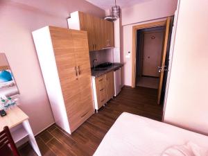 una pequeña cocina con armarios de madera y una mesa. en Figen Suite Hotel 2 en Çanakkale
