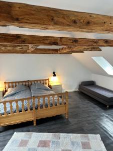 a bedroom with a wooden bed and a couch at Attic Room in Korsør