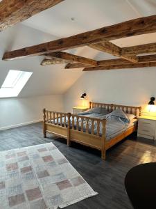 a bedroom with a wooden bed in a room with wooden ceilings at Attic Room in Korsør