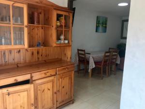 ベグールにあるCasa Begurのキッチン(木製キャビネット、テーブル、椅子付)