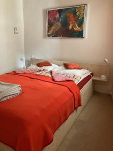 een slaapkamer met een bed met een rode deken bij Neffies Languedoc Frankrig in Néffiès