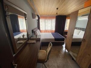 a bedroom with two beds and a desk and a mirror at City House Hotel in Antalya