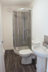 uma casa de banho com um chuveiro, um WC e um lavatório. em Cosy 1Bed Apartment in Heywood with Free Parking em Heywood