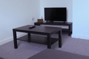 a living room with a coffee table and a flat screen tv at Cosy 1Bed Apartment in Heywood with Free Parking in Heywood