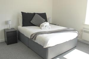 un letto con asciugamani in una camera da letto di Cosy 1Bed Apartment in Heywood with Free Parking a Heywood