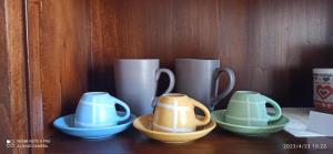 a group of cups and bowls on a shelf at La casa del golfo in Gavorrano