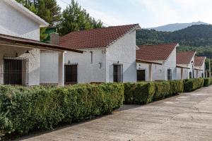 a row of houses with hedges next to a street at Complejo Rural Rio Tus in Yeste