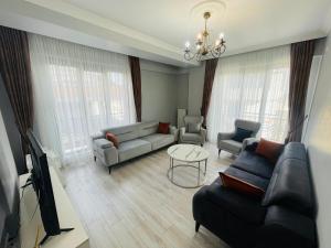 a living room with a couch and chairs and a tv at Aymira Residence Alibeyköy in Istanbul