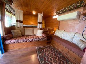 Habitación pequeña con sofá en una casa de madera en Zimmerbus en ‘Ezuz