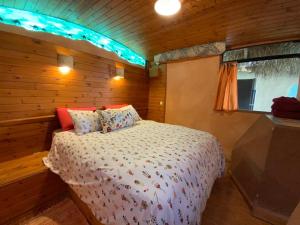 um quarto com uma cama num chalé de madeira em Zimmerbus em ‘Ezuz