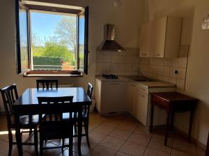 une cuisine avec une table et des chaises ainsi qu'une fenêtre dans l'établissement La Cascina Del Castello, à Asti