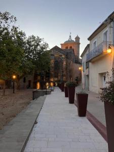 un trottoir avec un bâtiment et quelques plantes dans l'établissement Neffies Languedoc Frankrig, à Néffiès