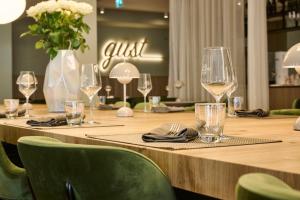 a long wooden table with wine glasses on it at Hotel Atlantic Juist in Juist