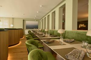 a row of tables and green chairs in a restaurant at Hotel Atlantic Juist in Juist