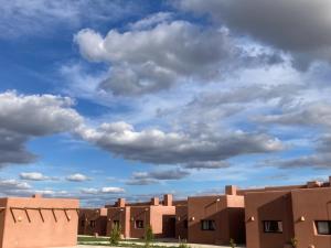 a row of brown buildings under a cloudy sky at La Cobija Apartamentos - Solo Adultos in Ciudad Real