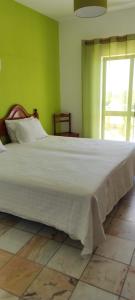 a large white bed in a room with a window at Vivenda Familia Pedro in Vila do Bispo