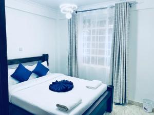 a bedroom with a bed with a blue umbrella on it at Arabel's Place 1 Bedroom California Plaza Nanyuki in Nanyuki