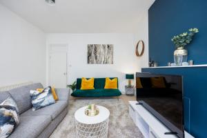 a living room with a gray couch and yellow pillows at Stylish Apartment Opposite Westfields in London