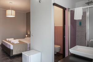 een slaapkamer met een bed en een badkamer met een wastafel bij B&B Bellavista in Margherita di Savoia