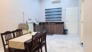 a kitchen with a table and chairs and a kitchen with a window at BRICK HOMESTAY in Teluk Intan