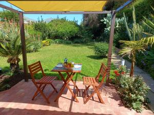 een patio met 2 stoelen en een tafel met fruit erop bij Cozy Suite&Lodge Mondello beach in Palermo