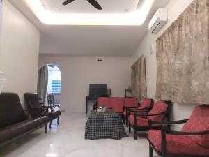 een wachtkamer met rode stoelen en een bank bij BRICK HOMESTAY in Teluk Intan