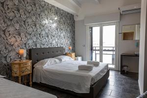 - une chambre avec un grand lit et une grande fenêtre dans l'établissement B&B Bellavista, à Margherita di Savoia