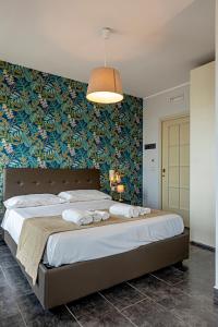 una camera da letto con un grande letto con carta da parati blu e verde di B&B Bellavista a Margherita di Savoia