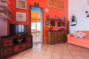 uma sala de estar com um sofá e uma televisão em Il Pesce e il Geco em Lipari